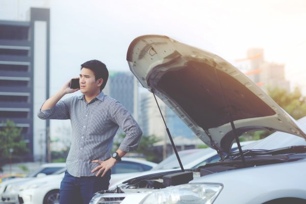 car with open hood broke down man talking on mobile phone autopom! features extended car warranty